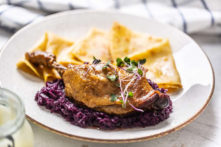 Portion of duck leg with red cabbage and potato pancakes, a traditional autumn dish in Eastern Europe.の写真素材
