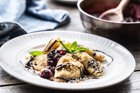 Freshly made pierogi served with forest berries sauce and mint leaves on top.