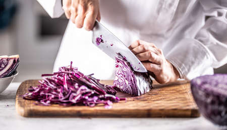Detail of a chef cutting red cabbage to thin slices.の写真素材