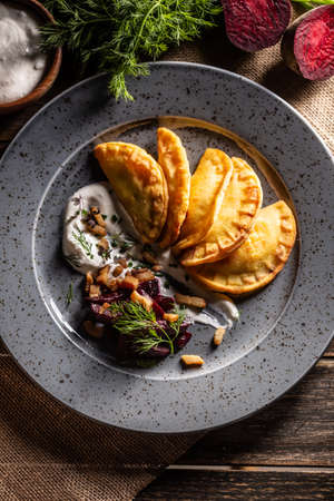 Baked homemade potato pies, creamy garlic dip, baked beetroot and roasted bacon - Top of view.の写真素材