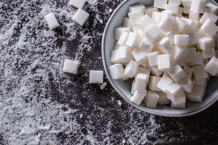 White sugar cubes in a blue bowl on the table - Top of view.の写真素材
