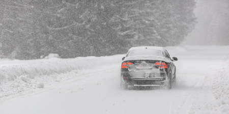 Liptov, Slovakia - JANUARY 30, 2022. Car covered in snow driving in snowstorm on a cold winter day.のeditorial素材