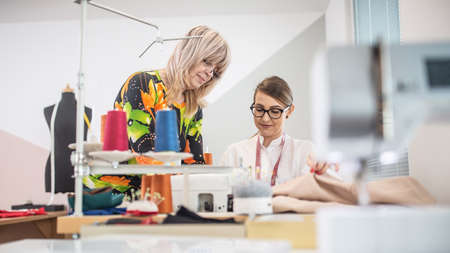 Two generations of female tailors cooperate at work in the small workshop.