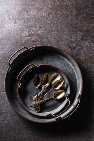 Antique trays with spoons on a rustic table - Top of view.の写真素材