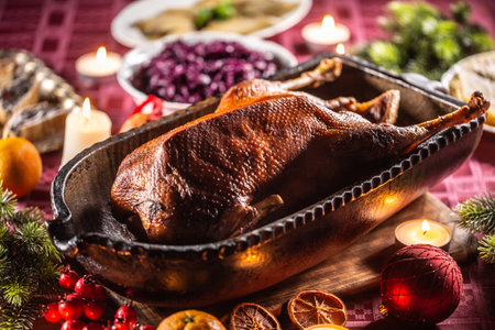 Christmas roast goose with red cabbage, flat bread in an original baking dish on the festive table.の写真素材