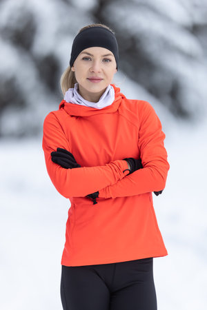 Portrait of a young runner in thermal clothing. Good looking female trainer in warm clothes during...