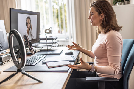 Screen view of a woman providing online customer service for an employee's office. A businesswoman gives an online interview with her client.の写真素材