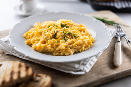 Appetizing breakfast full of proteins in a form of scrambled eggs in a plate.の写真素材