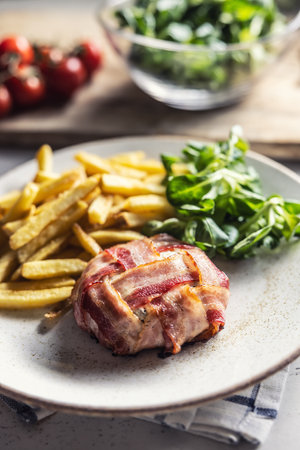 Camembert or brie cheese wrapped in bacon, prosciutto,jamon, or prsut on a plate.の写真素材