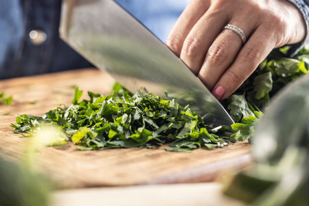 Green fresh parsley cut on a wooden board by a sharp knife.の写真素材
