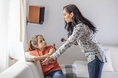 Conflict between generations as mother tries to take pc away from daughter who is always online.の写真素材