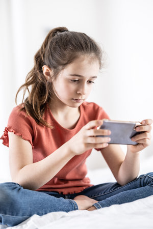 Pre-teen girl is addicted to being online, having fomo and having her phone in hands at all times.の写真素材