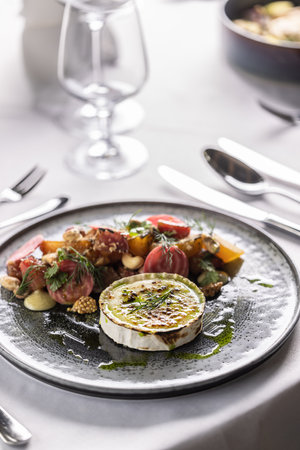 Goat cheese with baked beetroot salad styled on a plate in a restaurant.の写真素材