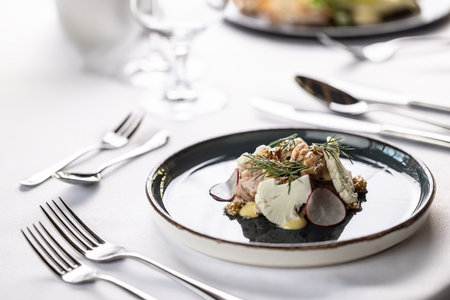 Luxurious appetizer in a restaurant with pork, cauliflower, vegetables and dressing.の写真素材
