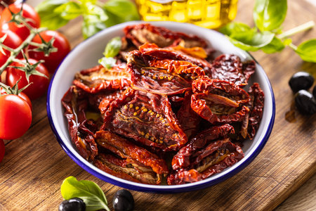 Sun-dried tomatoes marinated in olive oil with herbs and olives.の写真素材