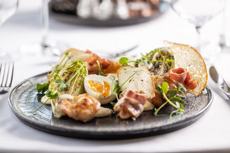 Appetizer in a form of ceasar salad with shrimps, toasts and egg.の写真素材