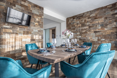 Dining room with wooden table and blue chairs floor in modern apartment.の写真素材