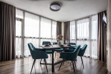 Dining room with wooden table and blue chairs floor in modern apartment.の写真素材