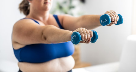 Close-up view of fat woman holding dumbbells. Woman diet weight loss overweight problem concept.