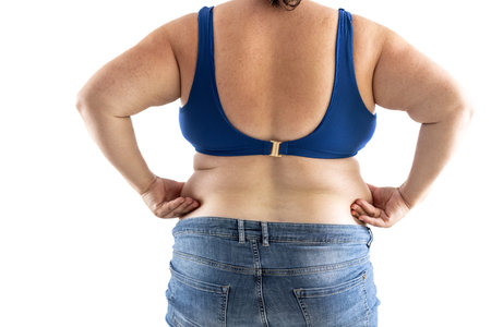 Plus size overweight woman holds her hips full of fat - Isolated on white.の写真素材