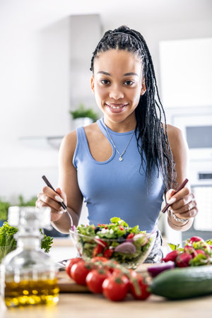 Female hands mixing a healthy spring salad made from various ingredients. Concept of healthy lifestyle.の写真素材
