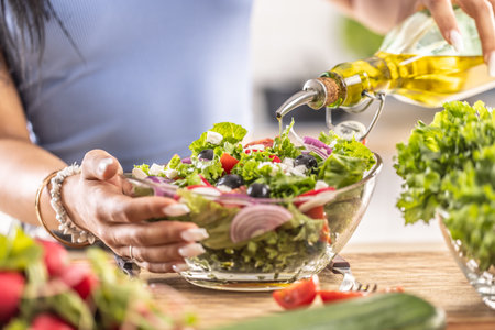 The final preparation of a healthy salad and at the end the woman pours olive oil.の写真素材