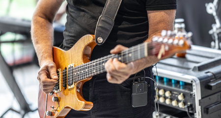 Guitarists play at a rock or rock n roll concert. A guitarist plays chords on an electric guitar.の写真素材