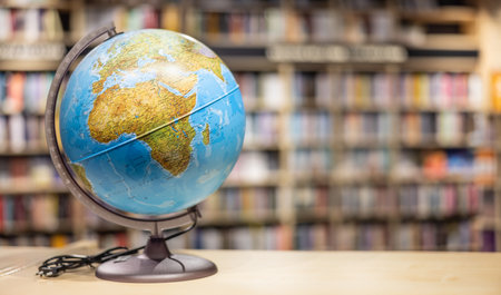 A globe as school equipment placed on a shelf in the school library. Space for text.の写真素材