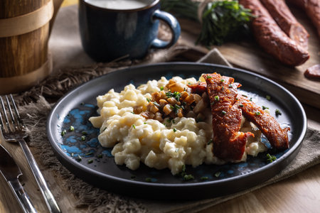 Halusky as traditional Slovak potato gnocchi with sheep cheese bryndza, fried bacon,sausage and chives.の写真素材
