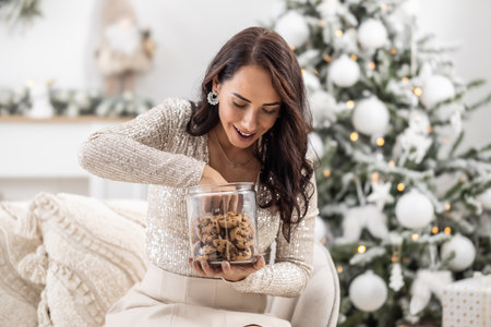 Woman is exciting to take a cookie out of the jar during Christmas.の写真素材