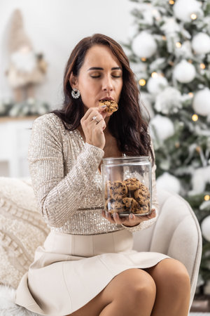 Woman indulges in the pleasure of eating a chocolate chip Christmas cookie.の写真素材