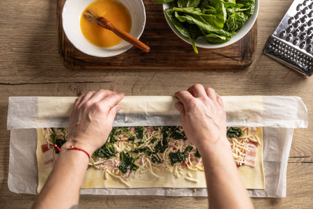 The cook rolls puff pastry with bacon, spinach and cheese, prepares mini pizza cakes - Top of view. Recipe procedure: 5 of 10の写真素材