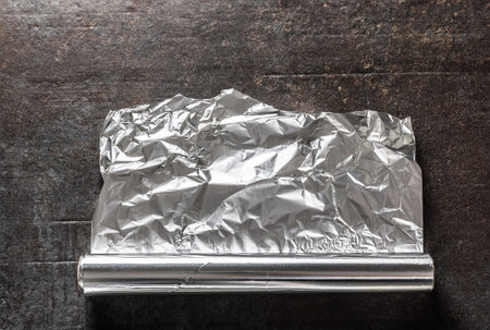 Aluminium foil on dark concrete background.の写真素材