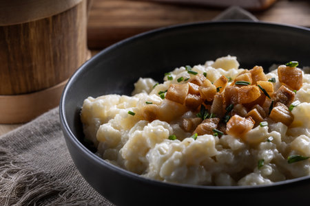 Halusky as traditional Slovak potato gnocchi with sheep cheese bryndza, fried bacon and chives.の写真素材
