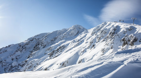 View of the snow-covered hills of the Low Tatras - Jasna and the cable car that takes skiers to Chopok mountain.の写真素材