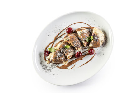 Eastern European traditional food dumplings - pierogi, varenyky, pirohy filled with strawberries and topped with chocolate. Isolated on white.の写真素材