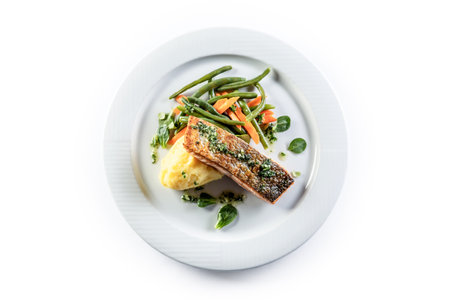 Baked salmon fillet with mashed potatoes and English vegetables on a white isolated background.の写真素材