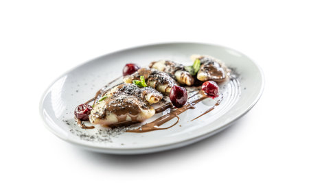 Eastern European traditional food dumplings - pierogi, varenyky, pirohy filled with strawberries and topped with chocolate. Isolated on white.の写真素材