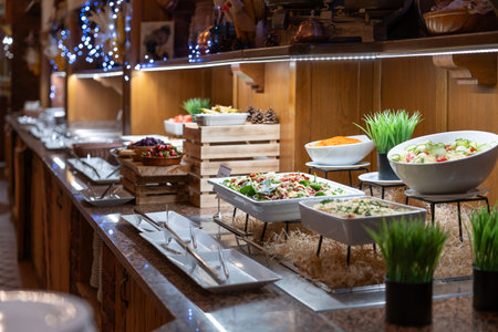 Buffet table full of dishes and salads ready for dinner for hotel guests.
