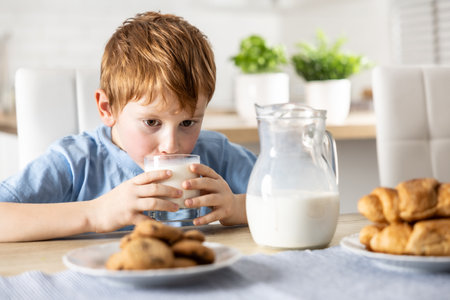 Cute boy drinks fresh milk for breakfast.の写真素材