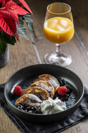 Pancakes with blueberry jam and raspberries in a bowl.の写真素材