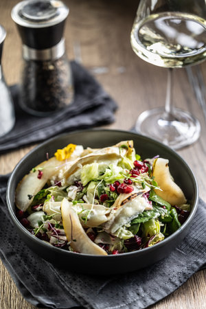 Healthy salad with goat cheese, lettuce, pears and pomegranate.の写真素材