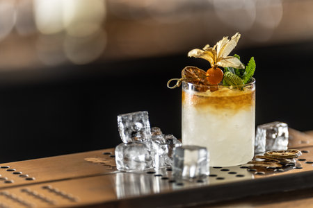 Exotic Mai Tai cocktail drink decorated with physalis and mint on the bar counter of the pub.の写真素材