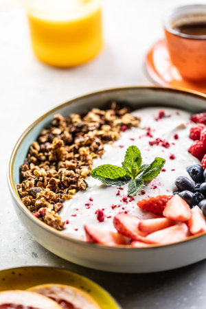 A bowl full of berries, yogurt and cereal. Healthy breakfast concept.の写真素材