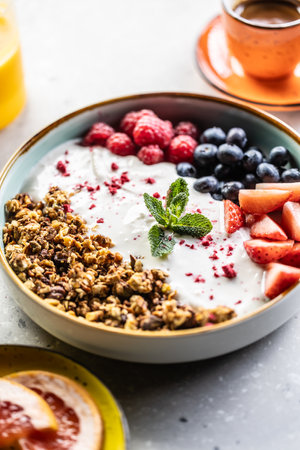 A bowl full of berries, yogurt and cereal. Healthy breakfast concept.の写真素材