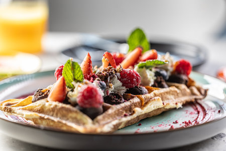 Homemade waffles with strawberries, raspberries and whipped cream.の写真素材