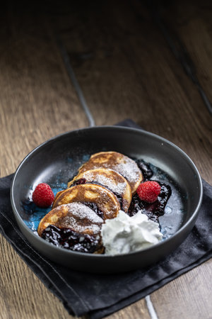 Pancakes with blueberry jam and raspberries in a bowl.の写真素材
