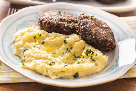 Mashed potatoes topped with melted butter as a side dish to meatballs.