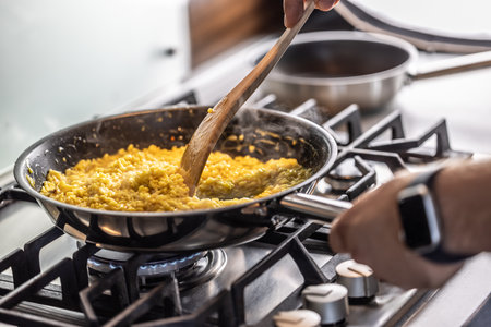 Preparation of saffron risotto in a pan on a gas stove.の写真素材