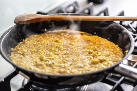 Preparation of saffron risotto in a pan on a gas stove.の写真素材